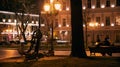 Scene of the evening city with a couple sitting on a bench and a ship`s anchor monument near the Opera theatre in Odessa Ukraine Royalty Free Stock Photo