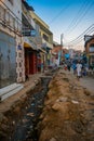 Poverty in Africa: an open sewage in the streets of Antananarivo, Madagascar, black people, local africans nearby