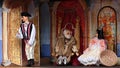 Scene from puppet theater - muddleheaded peasant son, king and princess in palace.