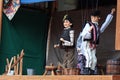Scene from puppet theater - muddleheaded son and his peasant father.