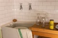 A scene from a 1960`s kitchen with tiles, a butler sink, wooden draining board and Vim cleaning powder