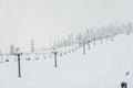 Scene of ski lift with seats  over the mountain and paths from skies and snowboard when sunset Royalty Free Stock Photo