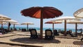 Sun umbrellas and lounge chairs on hotel sand beach,
