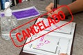 Scene of woman writes the date of her wedding in a personal organizer. stamp canceled in spanish by coronavirus. She is sitting at Royalty Free Stock Photo