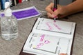 Scene of woman writes in a personal organizer the date of her wedding and honeymoon.She is sitting at a desk. A laptop, a cup of Royalty Free Stock Photo