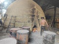 Scene of the worker putting mangrove logs into the charcoal kiln to produce pure carbon