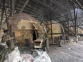 Scene of the worker putting mangrove logs into the charcoal kiln to produce pure carbon