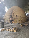 Scene of the worker putting mangrove logs into the charcoal kiln to produce pure carbon