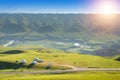 Scenery of alpine meadows with Mongolian yurts under sunlight