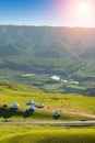 Scenery of alpine meadows with Mongolian yurts under sunlight