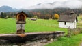 Scenery of a Bavarian farmland with a wooden trough, country houses & barns in a ranch on a foggy autumn morning Royalty Free Stock Photo