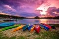 Scenery of beautiful sunset with colorful clouds and canoe resting beside of lakeside Royalty Free Stock Photo