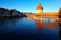 Scenery of Chapel Bridge Kapellbrucke and Water Tower bathed in warm golden sunlight over Reuss River in Lucerne Old Town, Swi