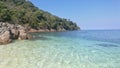 Scenery of clear crystal sea water on the beach with island of tropical forest, shade of blue sea and blue sky