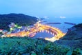 Scenery of coastal highway crossing the harbor of a fishing village with lights of fishing boats on the sea ~ Royalty Free Stock Photo