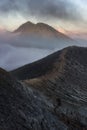 The scenery of the crater of Kawah Ijen with a large mountain covered by the mist behind in the morning at Java, Indonesia