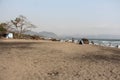 A scenery of a stretch of sand on a beach with large rocks from a distance Royalty Free Stock Photo