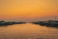 The scenery of the fishing community where a fishing boat is sailing in the canal to go out to sea to find fish in the evening