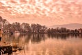 Scenery of Ioannina city lit up by red sunlight colors and glowing sky with reflections on the smooth lake water Royalty Free Stock Photo