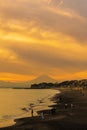 Scenery Kamakura Yuigahama Beach with Kamakura city and Fujisan mountain. Twilight silhouette Mount Fuji behind Enoshima island at Royalty Free Stock Photo