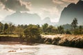 Scenery landscape of Nam Song River on winter dusk, golden sunlight shines through a mountain range on the valley and wild reed