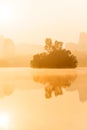 Scenery landscape of tropical lake in the morning mist, golden sun shining down on the lake and mountain range backdrop Royalty Free Stock Photo