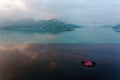 Scenery of a lotus blooming on an infinity pool & foggy mountains in background, reflected on the lake water Royalty Free Stock Photo