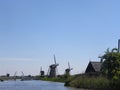 Scenery of mills near a river on a blue clear sky background Royalty Free Stock Photo