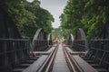 The scenery of an old woman walking alone on the bridge across the Kwai River in Kanchanaburi province, Thailand Royalty Free Stock Photo