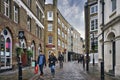 Scenery of people walking in the streets of Soho, London under the gloomy sky