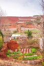 Scenery rural south Yunnan, China, vegetable garden and straw puppet on the Red Land of Dongchuan. Beautiful old village and trees Royalty Free Stock Photo