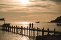 The scenery of the silhouette of the couple walking on the wood bridge in sunset time in Koh Kood island, Trat province, Thailand