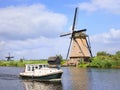 Scenery with a small boat and ancient windmill, Kinderdijk, Netherlands. Royalty Free Stock Photo