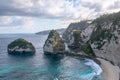 Scenery of sunny day with sand beach, turquoise ocean and mountains. View of Diamond beach, Nusa Penida, Bali island, Indonesia.