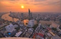 Scenery of sunset sky reflected on Chao Phraya River in Bangkok with Taksin Bridge over the river and skyscrapers along riverside Royalty Free Stock Photo