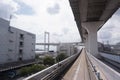 Scenery of a train traveling on the elevated rail of Yurikamome Line in Odaiba. Road under the bridge Royalty Free Stock Photo