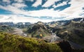 Scenery of Valahnukur viewpoint with female hiker standing on peak and krossa river through in icelandic highlands at Thorsmork,