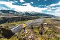 Scenery of Valahnukur viewpoint with female hiker standing on peak and krossa river through in icelandic highlands at Thorsmork,