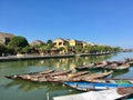 Mustard yellow building and boat on river at Hoi An ancient town, Vietnam