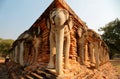 Scenery of Wat Sorasak, an ancient Buddhist Temple with elephant sculptures supporting the base of the stupa