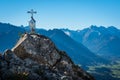 Scenery with a white cross on top of a rock in mountains Royalty Free Stock Photo