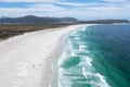 Scenic above view of wide sand beach and turquoise waves