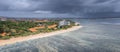 Scenic aerial panoramic view at beginning of Sanur beach with wide very shallow shore, dark heavy clouds before rain, Bali,