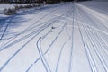 Scenic aerial view on adult driver pulled two children on snow racers with snowmobile, one child fall into snow - lost pulling