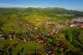 Scenic aerial view of the foggy Carpathian mountains, village and blue sky with clouds in morning light, summer rural landscape Royalty Free Stock Photo