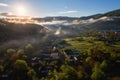 Scenic aerial view of the foggy Carpathian mountains, village and blue sky with clouds in morning light, summer rural landscape Royalty Free Stock Photo