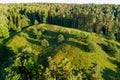 Scenic aerial view of Stirniai mound surrounded with green trees, located in Neris Regional Park near Vilnius, Lithuania, on sunny