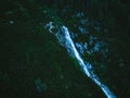 Scenic aerial view of waterfall flowing down lush green steep hill, long exposure