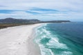 Scenic aerial view of wide sandy beach and turquoise ocean waves