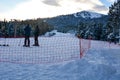 Scenic alpine landscape with two skiers waiting for ride in Karakol ski resort.